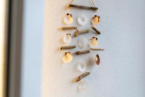 a white wall with shells and sticks on it at Marina Wendtorf Leuchtturmblick in Wendtorf
