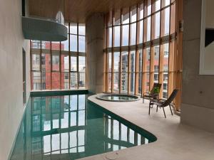 a large swimming pool in a building with windows at Nuevo Studio en Edificio Qanvas- Piso 19 - Parque La Carolina in Quito