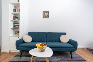 a blue couch with a bowl of fruit on a table at Apart house EMA 2 in Bansko