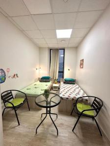 Zimmer mit einem Bett, 2 Stühlen und einem Tisch in der Unterkunft Affordable & Cozy Room In Riga Centre - Shared Facilities in Riga