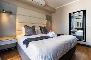 a bedroom with a large white bed with a mirror at 705 Icon Luxury Apartments in Cape Town +14 photos