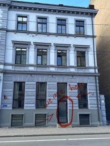 ein weißes Gebäude mit einem orangefarbenen Schlauch davor in der Unterkunft Affordable & Cozy Room In Riga Centre - Shared Facilities in Riga