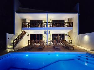 eine Villa mit Swimmingpool bei Nacht in der Unterkunft Makadal'Eau Boutique Resort in Siquijor