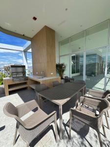 a patio with a table and chairs and a television at Nuevo Studio en Edificio Qanvas- Piso 19 - Parque La Carolina in Quito