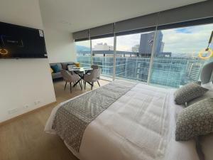 a bedroom with a large bed and a large window at Nuevo Studio en Edificio Qanvas- Piso 19 - Parque La Carolina in Quito +68 photos