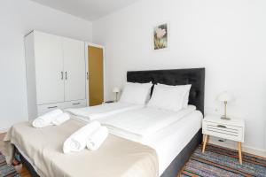 two beds in a bedroom with two white beds at Apart house EMA 2 in Bansko