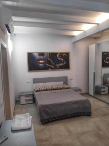 a bedroom with a bed and a painting on the wall at La Tavernetta delle Terme Euganee in Montegrotto Terme