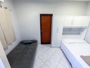 a small bedroom with a bed and a wooden door at Casa Studio"' São José dos Campos in São José dos Campos