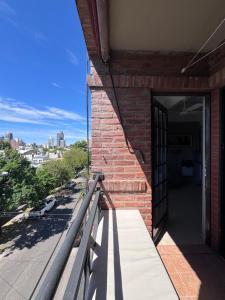 an open door to a brick building with a balcony at Temporario Mitre in Vuelta del Paraguayo