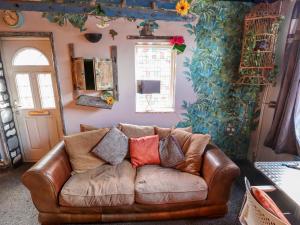 - un canapé en cuir brun dans le salon dans l'établissement Dormy Cottage, à Skegness 5 autres photos