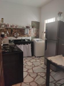 une cuisine avec une cuisinière et un réfrigérateur dans l'établissement Apartamento Retrô Aconchegante, à Pasto da Mata