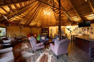 a living room with couches and chairs in a building at Mokolodi Backpackers in Gaborone