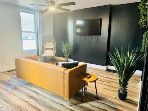 a living room with a yellow couch and a tv at Short North Convention King Bed Free Parking! in Columbus