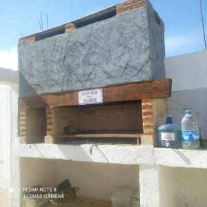 a sign on the side of a building with two water bottles at Estación La Perla in Alta Gracia