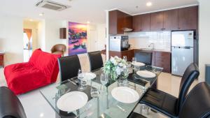 a dining room and kitchen with a glass table and chairs at PATONG TOWER SPACIOUS FAMILIES APARTMENT with 2 BATHROOMS 3&4 BEDROOMS Pta in Patong Beach
