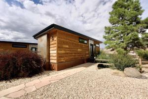 a small wooden cabin with a tree in front of it at Escalante Escapes Star Lily- Bunk Escape in Escalante