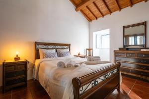 RelvaにあるMilena Guest Houseのベッドルーム1室(大型ベッド1台、ドレッサー、鏡付)