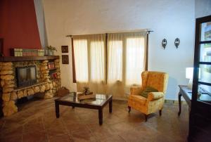a living room with a chair and a fireplace at Villa Rural Las Encinas in Alosno