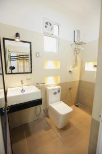 a bathroom with a white toilet and a sink at White Horse in Hikkaduwa +21 photos