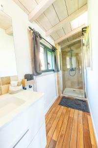 baño con ducha y suelo de madera. en Bergerie bien être, en Vaivre-et-Montoille