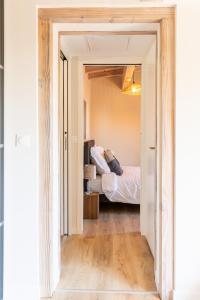 Puerta abierta a un dormitorio con cama en Bergerie bien être, en Vaivre-et-Montoille
