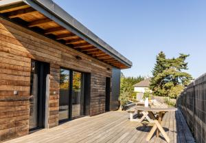 una terraza de madera con una mesa en una casa en Bergerie bien être, en Vaivre-et-Montoille