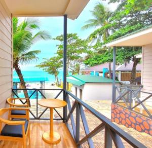 Un balcón con mesa y sillas y la playa. en Globiquex hotels, Phu quoc, en Phu Quoc