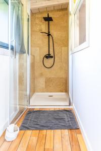 una ducha con una alfombra negra en una habitación en Bergerie bien être, en Vaivre-et-Montoille 9 fotos más
