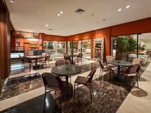 a restaurant with tables and chairs in a room at Hotel Gran Cacique Maiquetia in Maiquetía