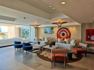 una sala de estar con sofás y una pintura en la pared en Hotel Gran Cacique Maiquetia, en Maiquetía