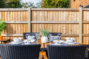 een tafel met stoelen en servies op een terras bij New 3 Bed House, Sittingbourne, Sleeps 7, Contractors, Families , Weekly and Monthly Offers in Milton Regis