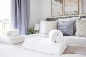een wit bed met handdoeken erop bij New 3 Bed House, Sittingbourne, Sleeps 7, Contractors, Families , Weekly and Monthly Offers in Milton Regis