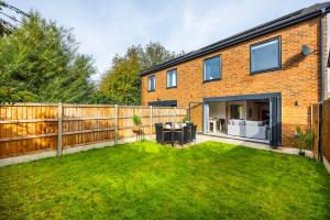 een achtertuin van een bakstenen huis met een hek bij New 3 Bed House, Sittingbourne, Sleeps 7, Contractors, Families , Weekly and Monthly Offers in Milton Regis +47 foto's