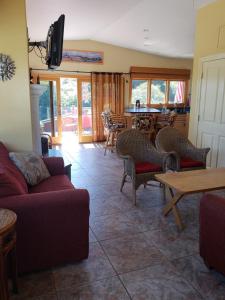 a living room with couches and tables and a television at Capitola Pelican House in Capitola
