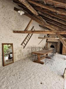 a dining room with a table and chairs and a mirror at L'évasion- Appartement cosy in Veuzain-sur-Loire
