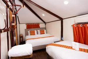 two beds in a small room with red curtains at Sarana Guest House in Luang Prabang
