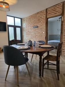 a dining room with a wooden table and chairs at L'évasion- Appartement cosy in Veuzain-sur-Loire
