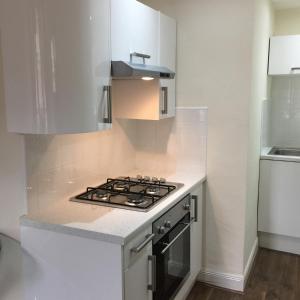 グラスゴーにあるTrefoil Apartment - 2 Bedroomsのキッチン(コンロ、白いカウンタートップ付)