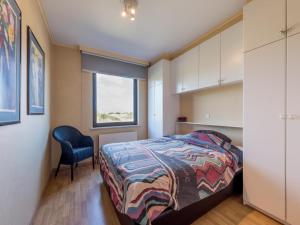 a bedroom with a bed and a chair at Aubépine premier in Sint-Idesbald