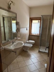 une salle de bain avec un lavabo, une douche et des toilettes dans l'établissement Locanda Al Cacciatore, à Nervesa della Battaglia 114 autres photos