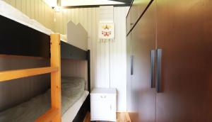 een kleine kamer met 2 stapelbedden en een koelkast bij Cosy Cabin Escape with Hot Tub & Lake View in Lundur