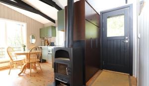 een keuken met een fornuis, een tafel en een deur bij Cosy Cabin Escape with Hot Tub & Lake View in Lundur