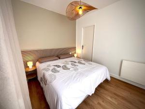 - une chambre avec un lit blanc et un ventilateur dans l'établissement La bohème du clocher - Cosy calme hyper-centre 2 à 6 pers, à Bergerac