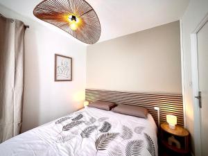 une chambre avec un lit et un grand ventilateur dans l'établissement La bohème du clocher - Cosy calme hyper-centre 2 à 6 pers, à Bergerac