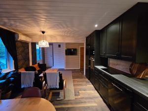a kitchen with a dining table and a living room at Villa Blackberry, nära Kolmården & Norrköping in Åby