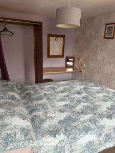 a large bed in a bedroom with a table at Holly cottage in Catfield