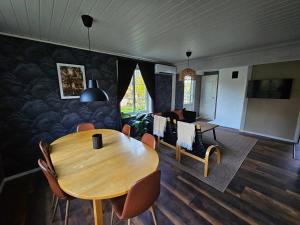 a dining room with a wooden table and chairs at Villa Blackberry, nära Kolmården & Norrköping in Åby