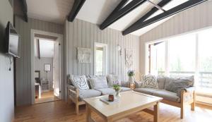 een woonkamer met een bank en een tafel bij Cosy Cabin Escape with Hot Tub & Lake View in Lundur