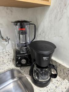a blender sitting on a counter next to a sink at Apartamento pé na areia em Tramandaí in Tramandaí
