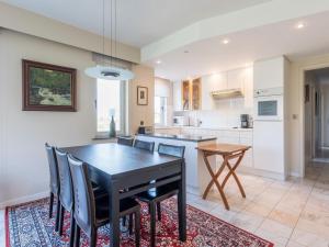 a kitchen with a black dining table and chairs at Aubépine premier in Sint-Idesbald
